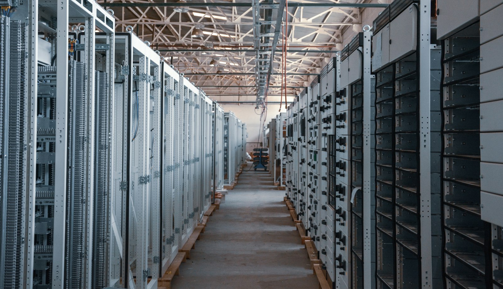 A long server room aisle lined with racks of equipment